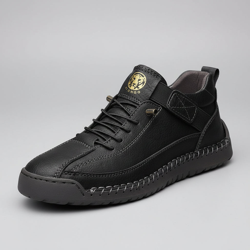Black leather sneaker with a brand logo on a wooden surface