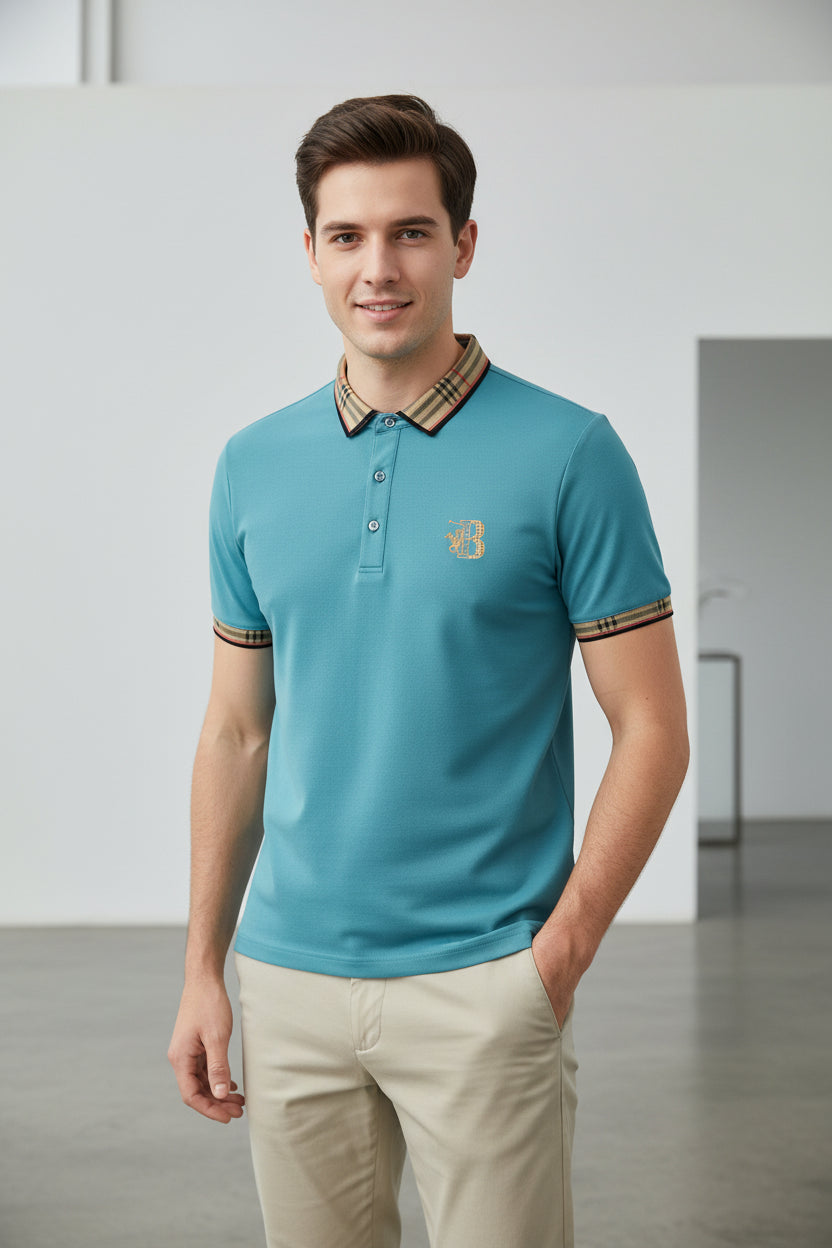 Light blue polo shirt with plaid collar and brand logo, accompanied by a watch on a gray surface.
