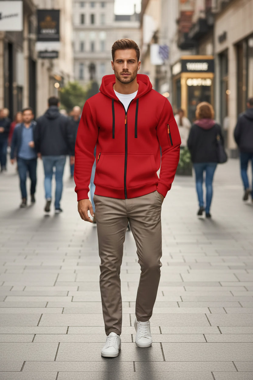 Person wearing a red hoodie with black zippers in an urban setting