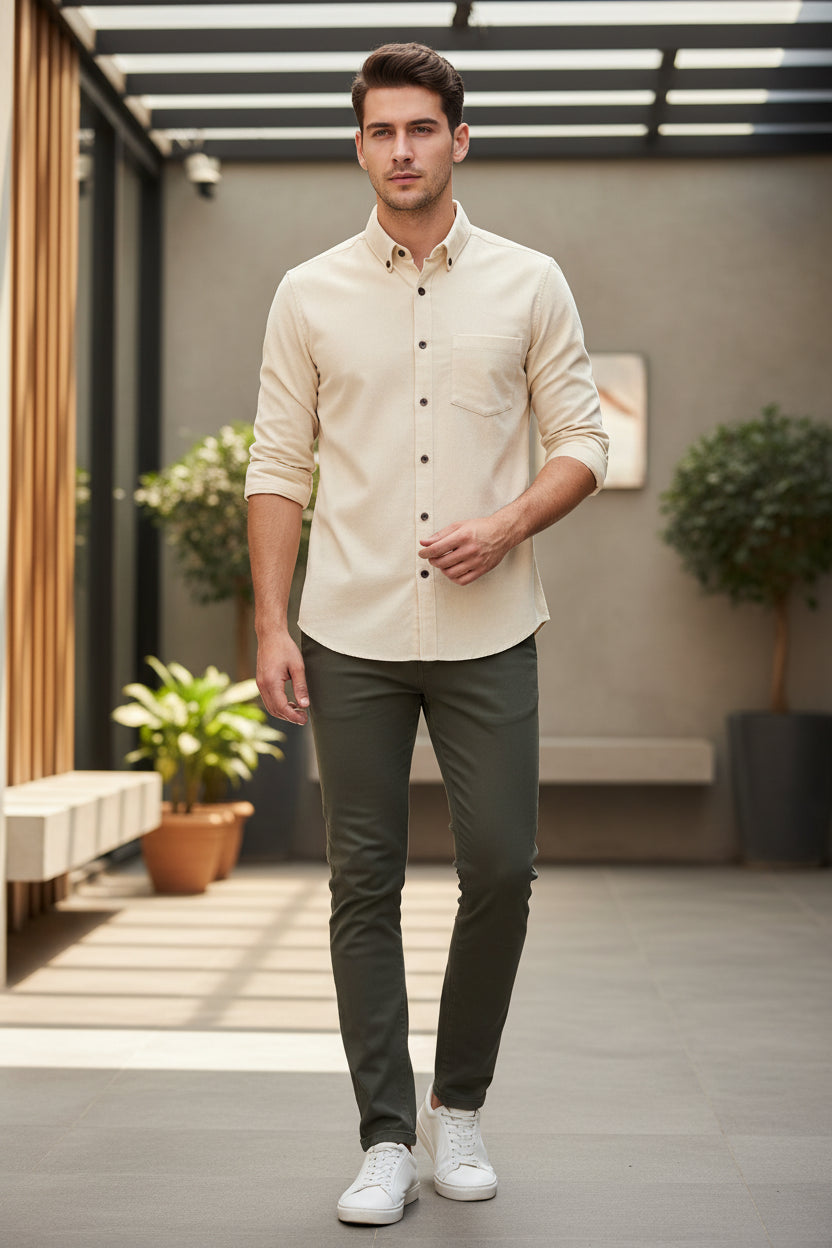 Beige shirt on a hanger against a gradient gray background