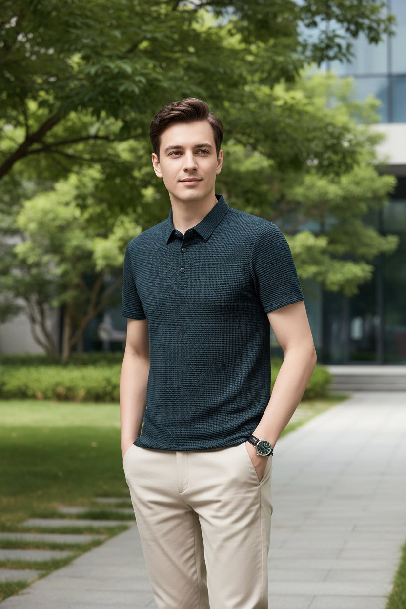Man wearing a dark blue textured polo shirt against a gray background