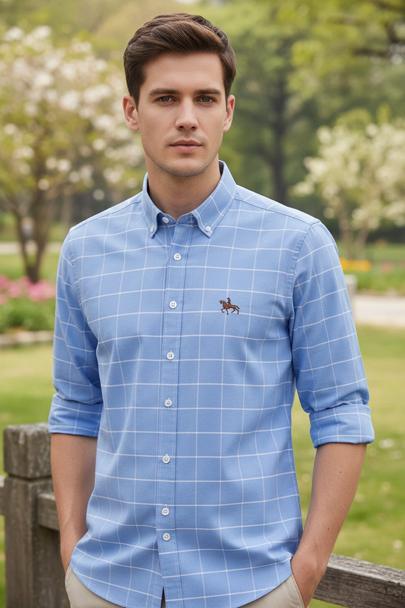 Folded blue checkered shirt with a brand logo on a light gray background