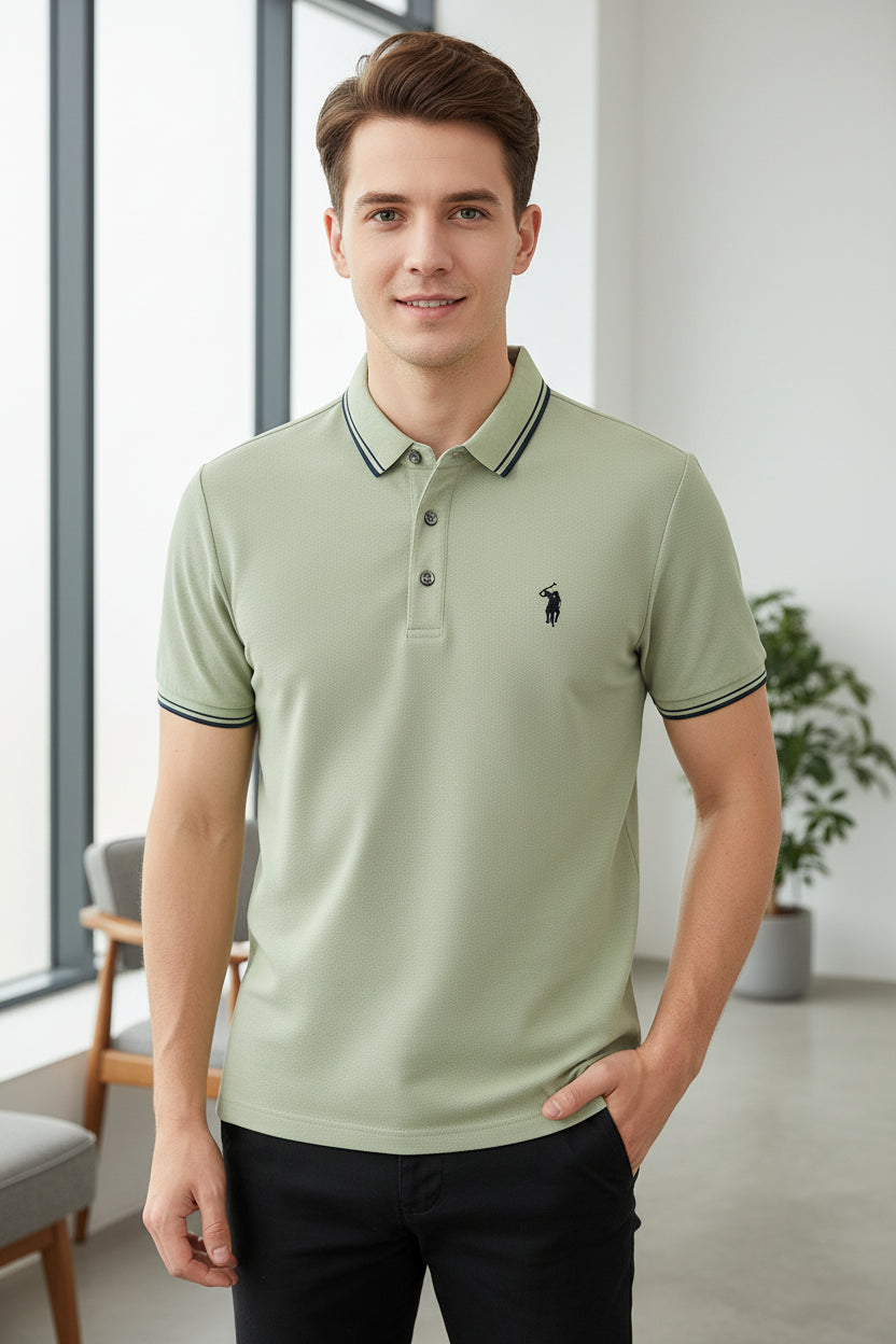 Light green polo shirt with a brand logo held by a hand in a store setting.
