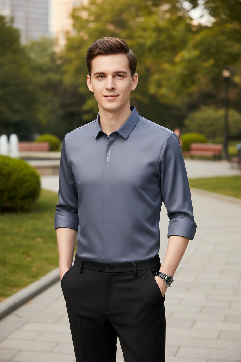 Gray dress shirt with rolled-up sleeves worn by a person on a gray background