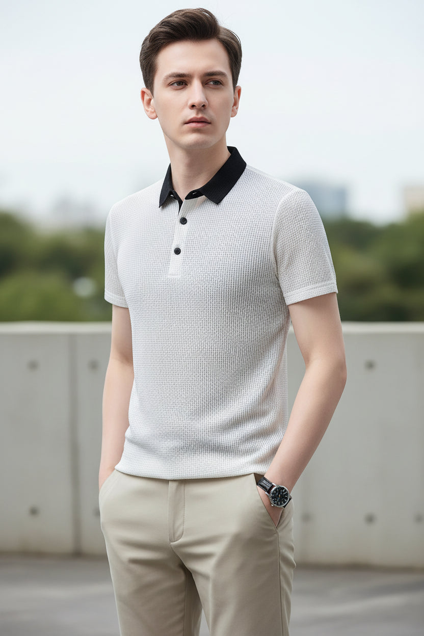 Man wearing a light gray textured polo shirt with black buttons on a gray background