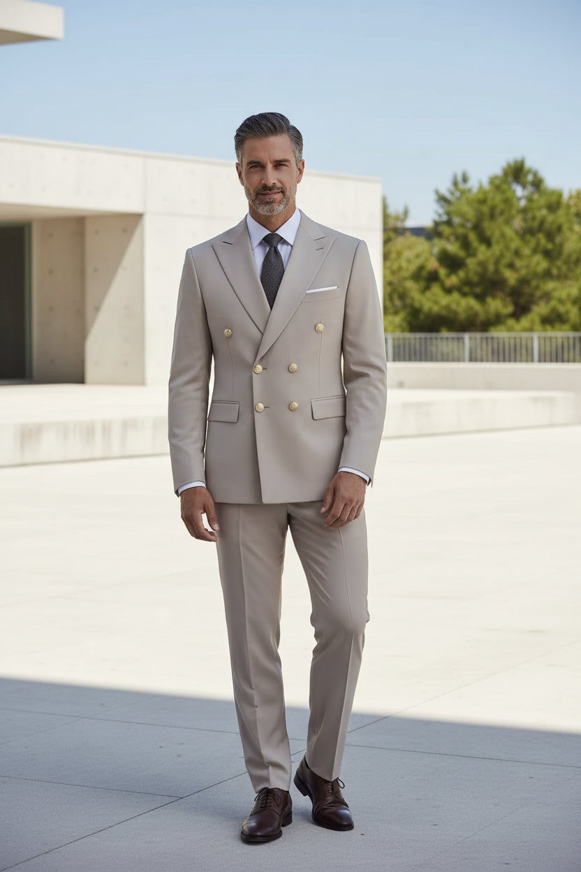Man wearing a beige suit with gold buttons on a gray background