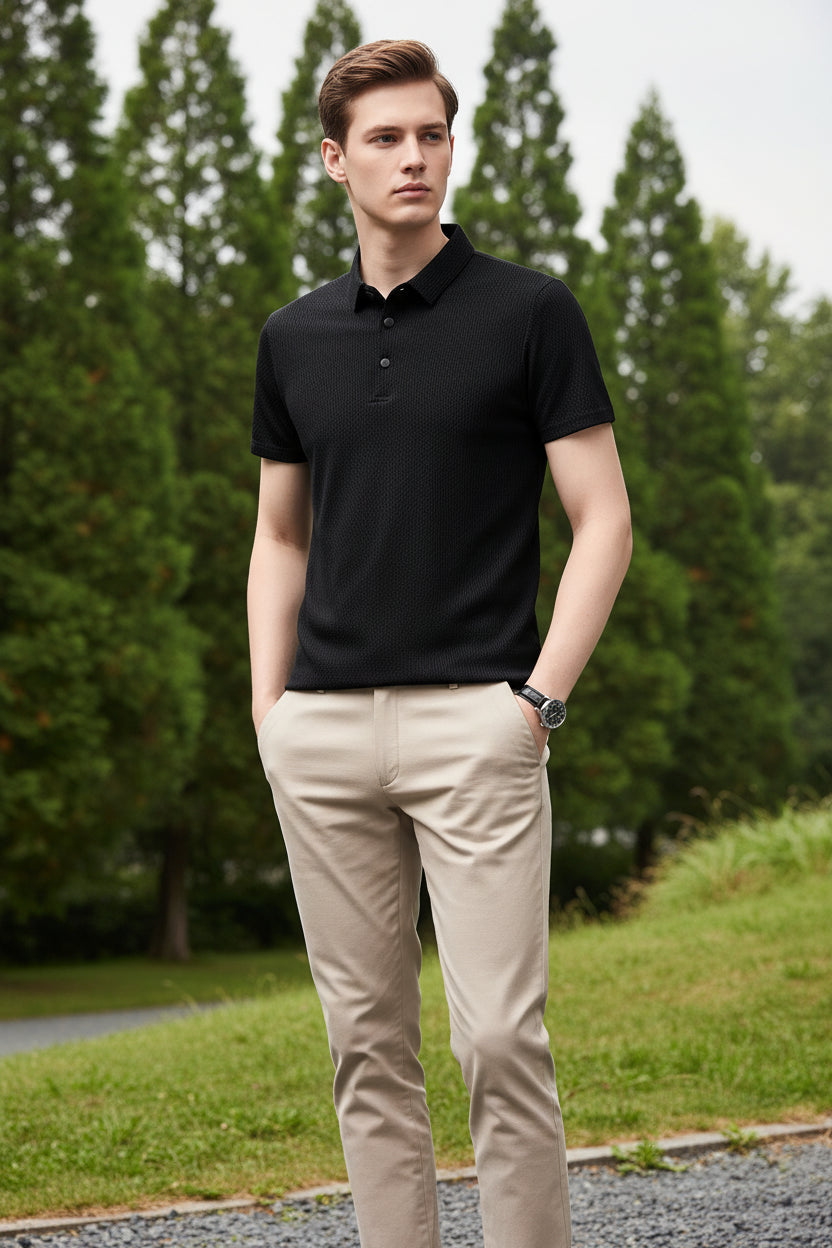 Black textured polo shirt worn by a person on a gray background