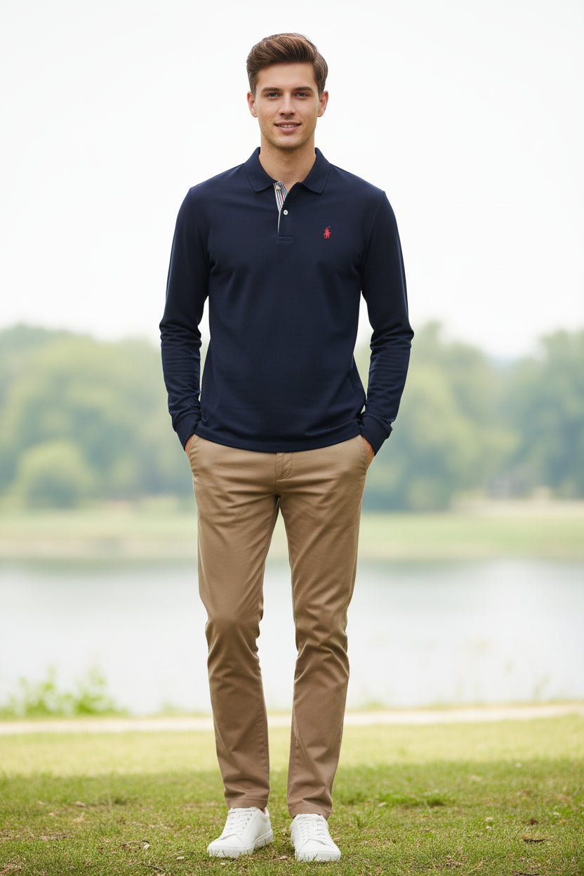 Navy long-sleeve polo shirt with a small red logo on a rack with other colored shirts.