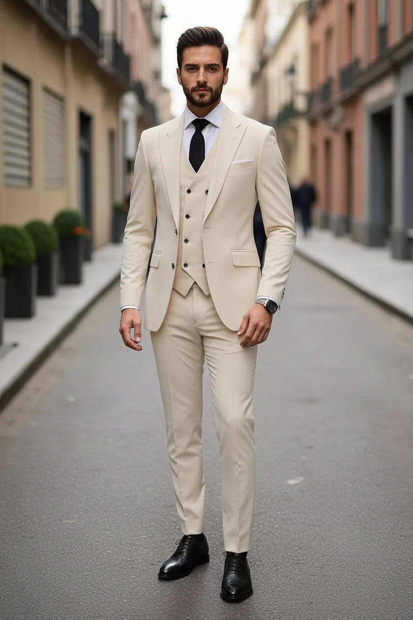 Man wearing a beige suit with a black tie on a city street.