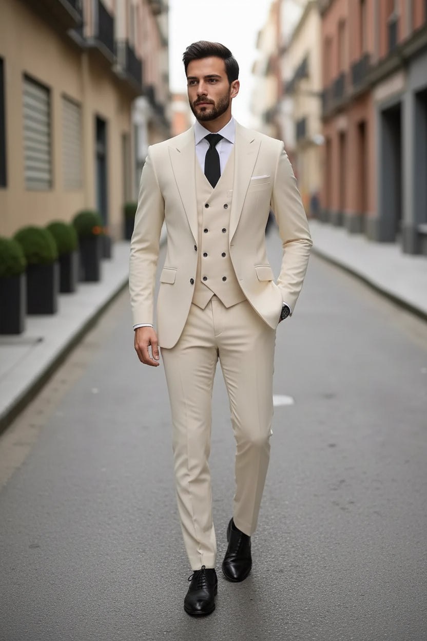 Man wearing a beige suit with a black tie on a city street.