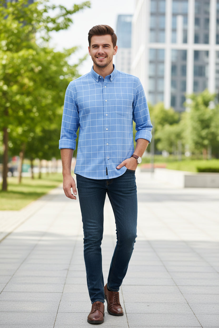 Folded blue checkered shirt with a brand label on a light gray background