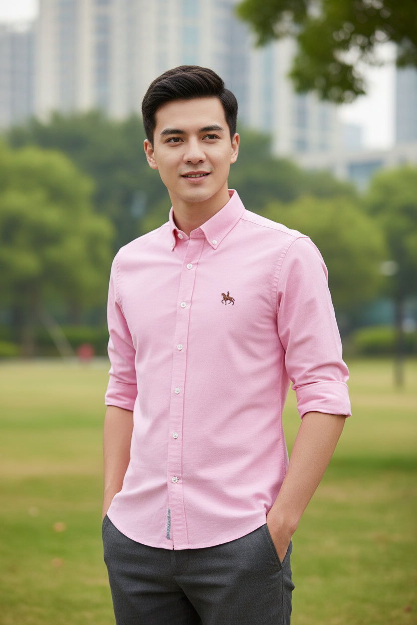 Folded pink shirt with a brand logo on a light gray background