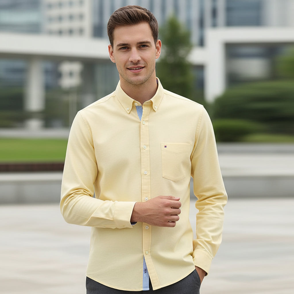 Folded yellow shirt with a brand label on a white background