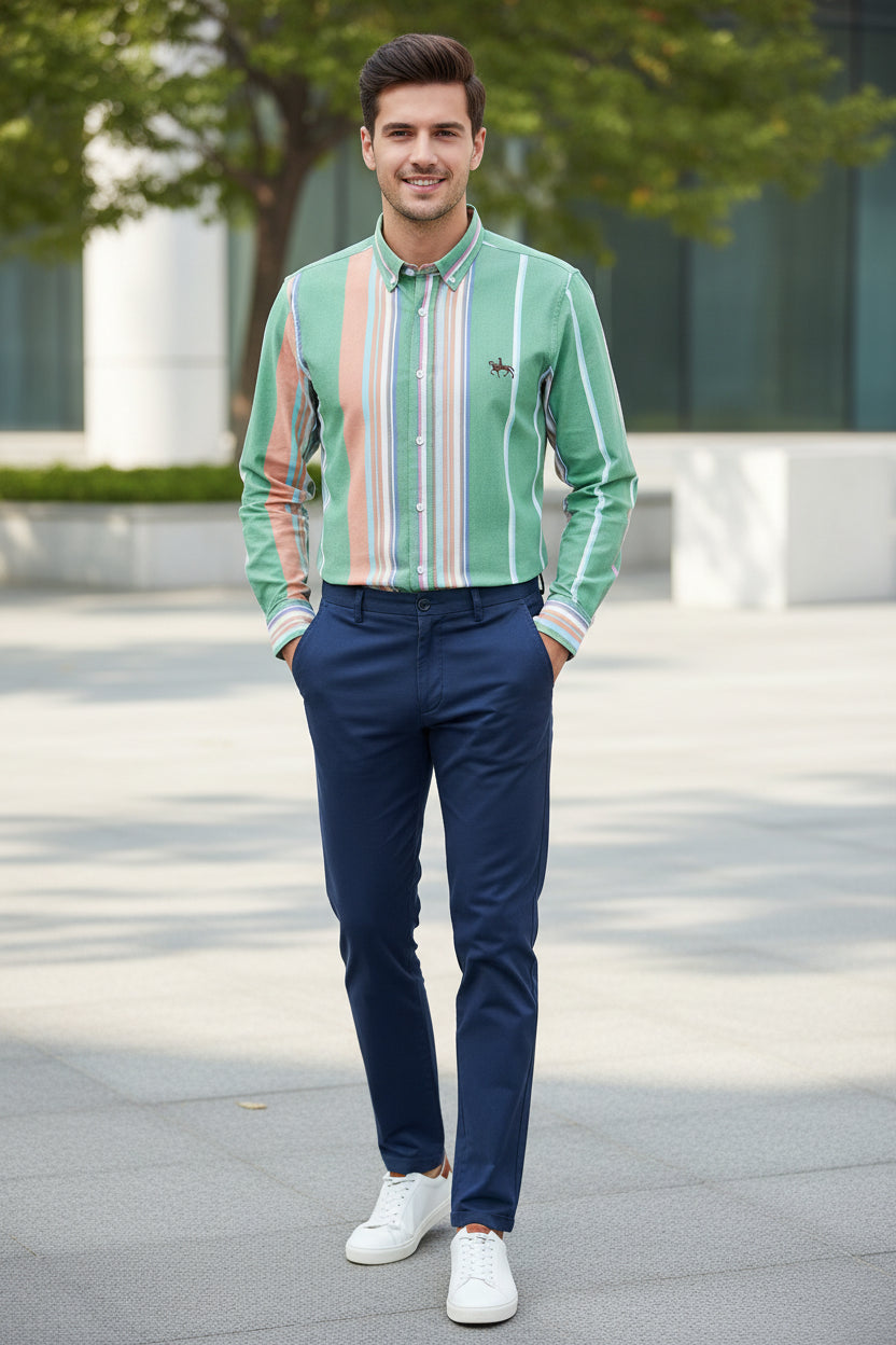Folded green shirt with multicolored stripes on a white background