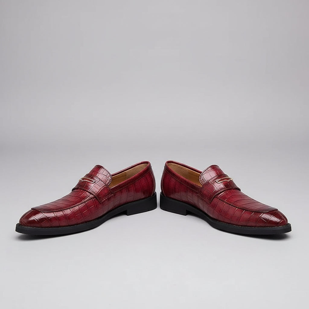 Red leather shoes with a textured pattern worn on a wooden floor.