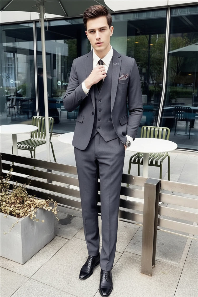 Person wearing a gray suit sitting on a bench outdoors.