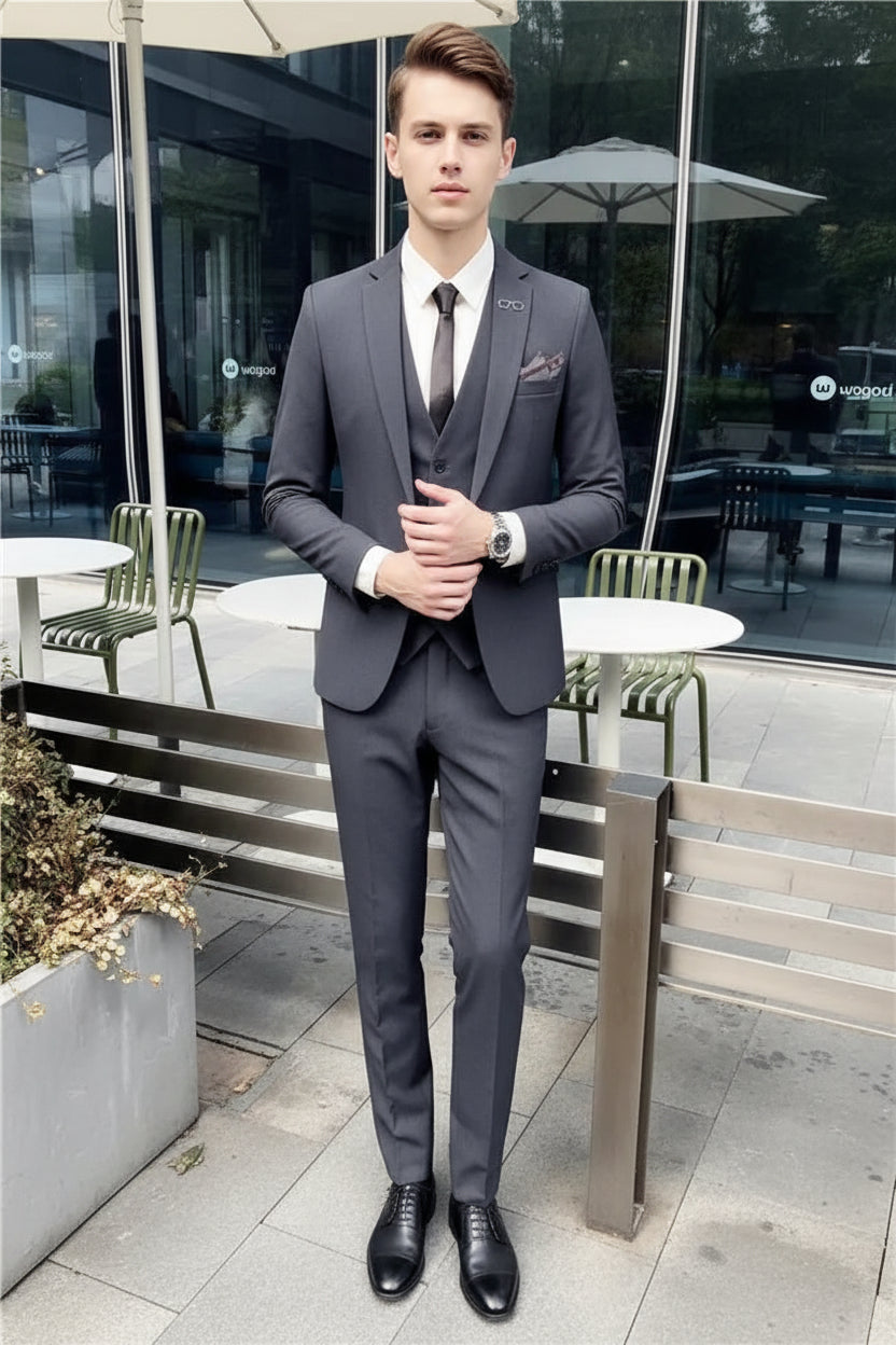 Person wearing a gray suit sitting on a bench outdoors.