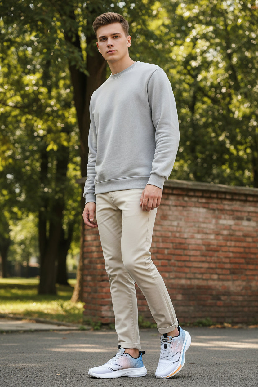 White running shoes with blue and orange accents worn by a person on a gray background