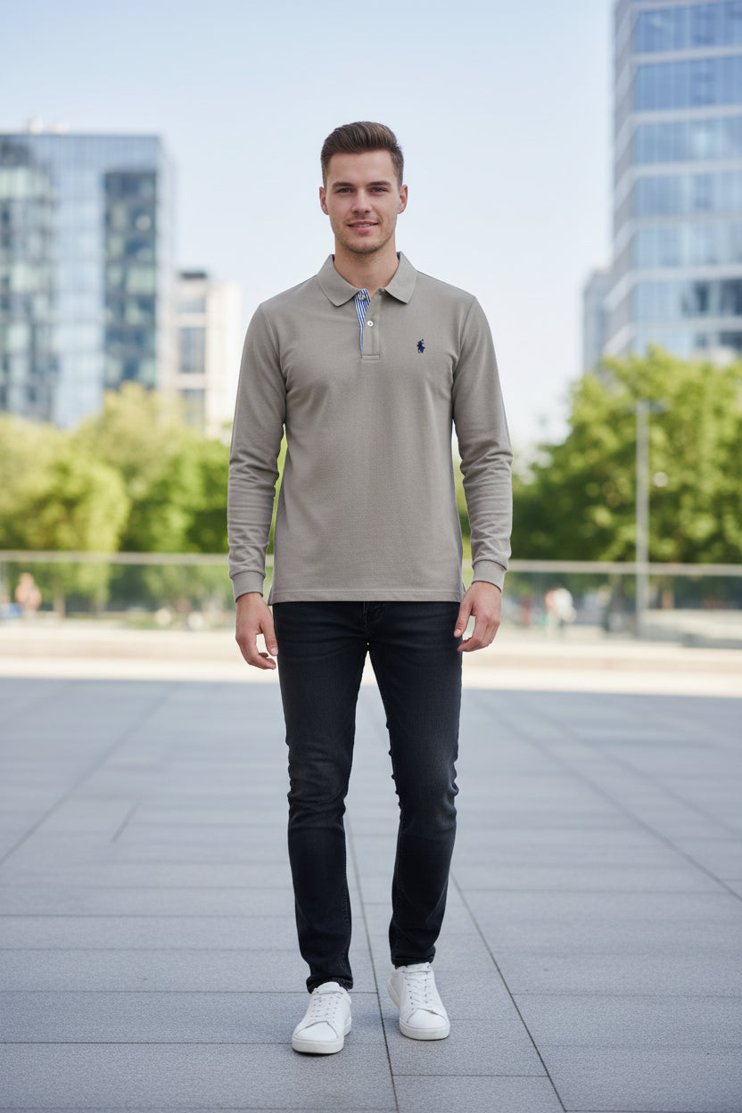 Gray polo shirt with a brand logo on a hanger against a blurred clothing rack background