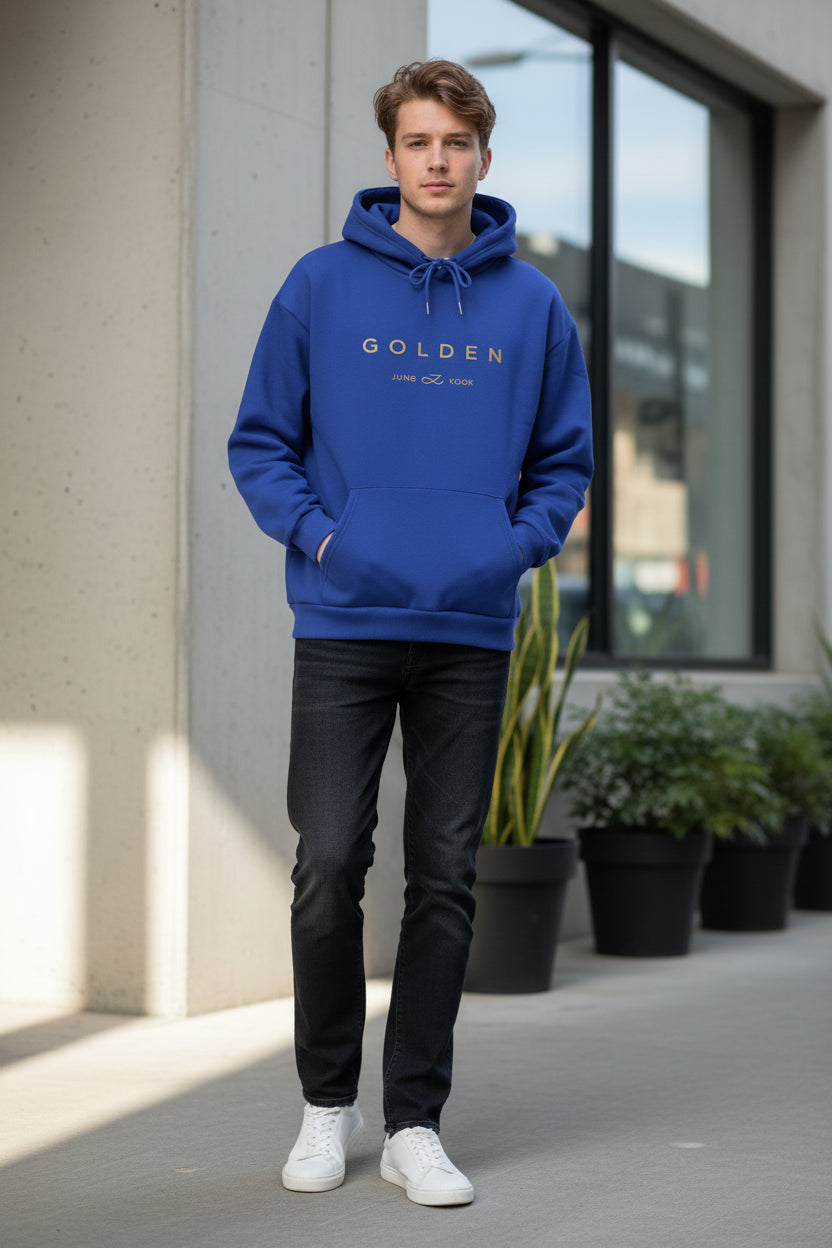 Blue hoodie with 'GOLDEN' text on a surface with newspapers underneath