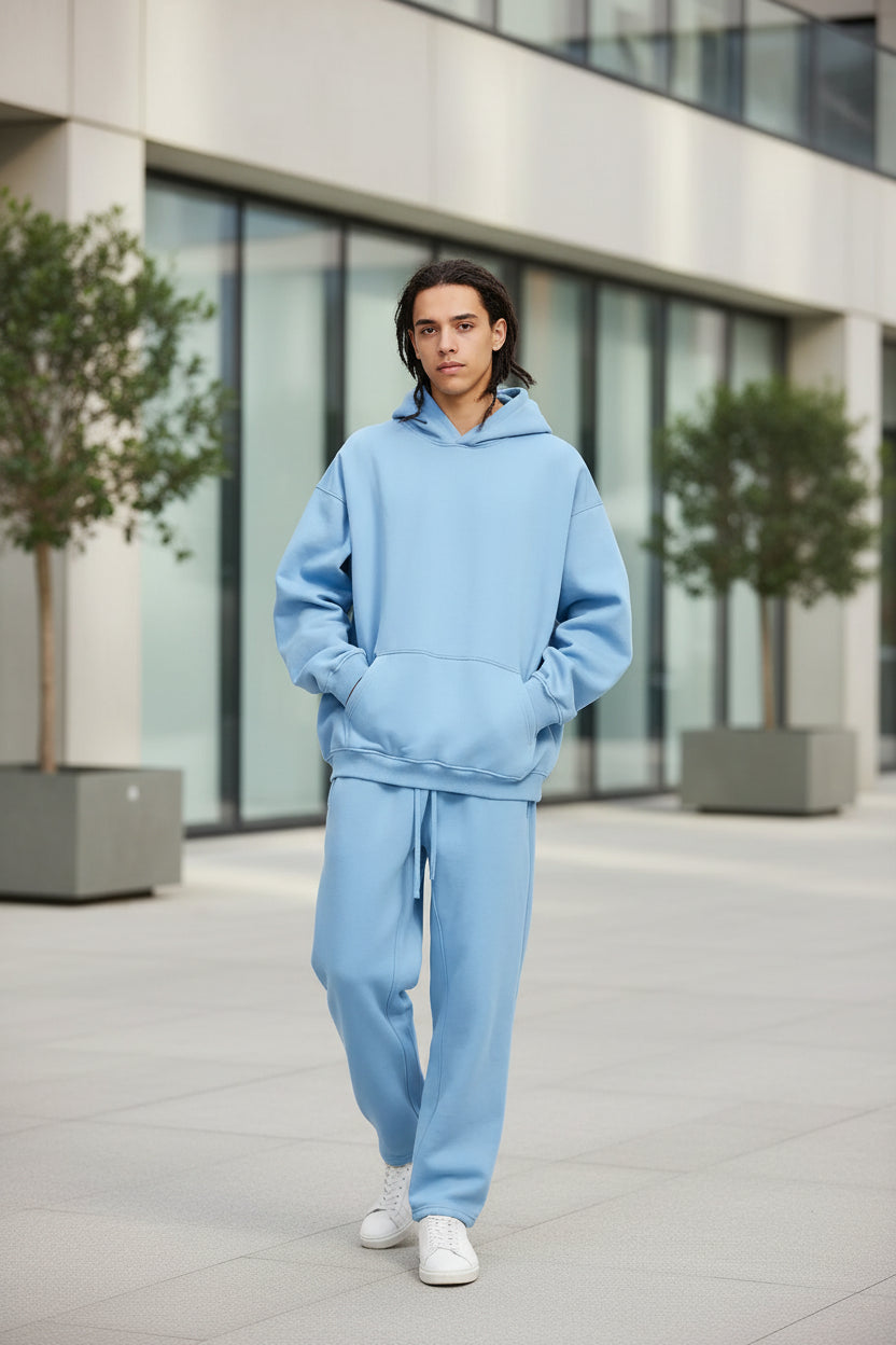 Person wearing a light blue hoodie and pants on a white background