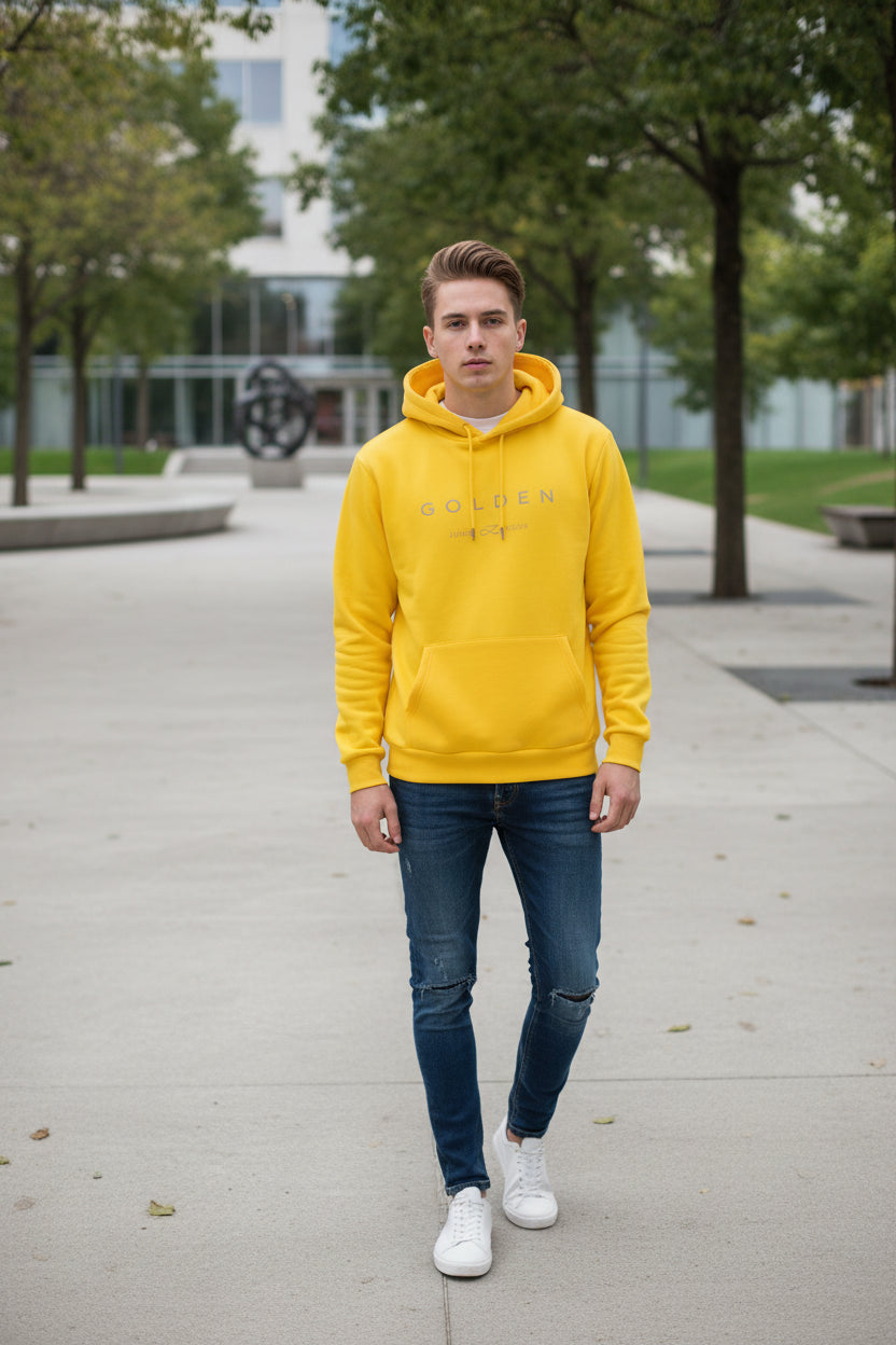 Yellow hoodie with a white graphic design on a textured surface