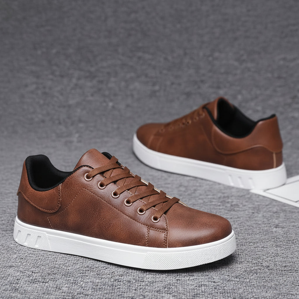 Brown leather sneakers with white soles on a gray surface