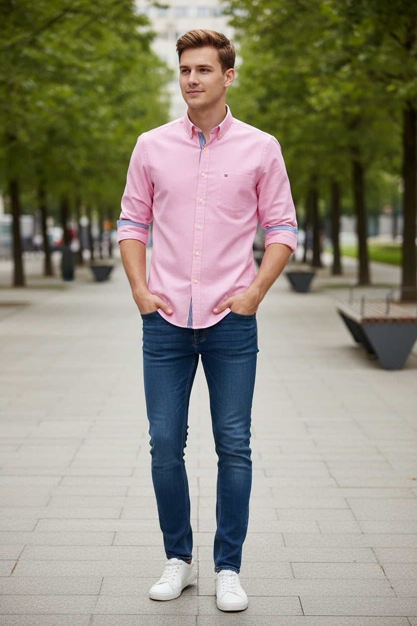 Pink dress shirt with a brand logo on a light gray background