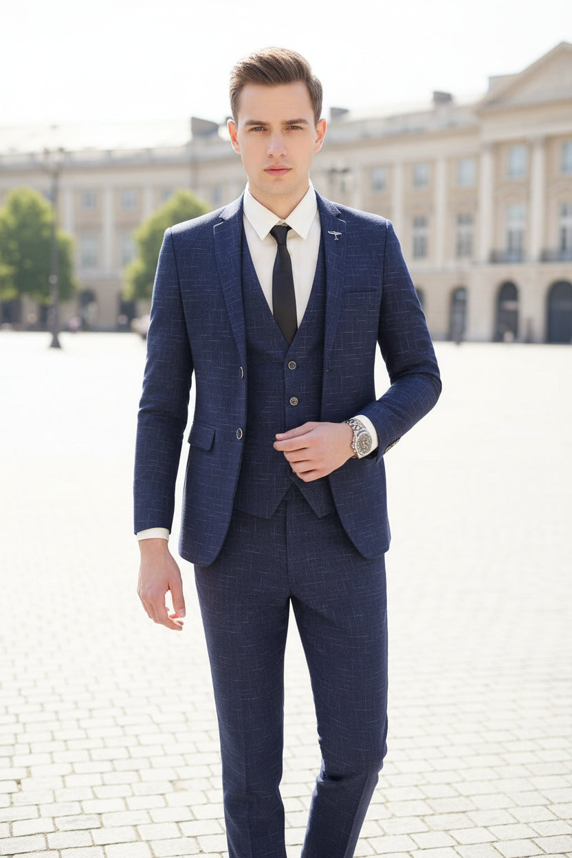 Person wearing a blue checkered suit standing in front of a glass door with reflections.