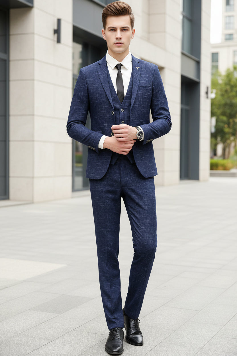 Person wearing a blue checkered suit standing in front of a glass door with reflections.