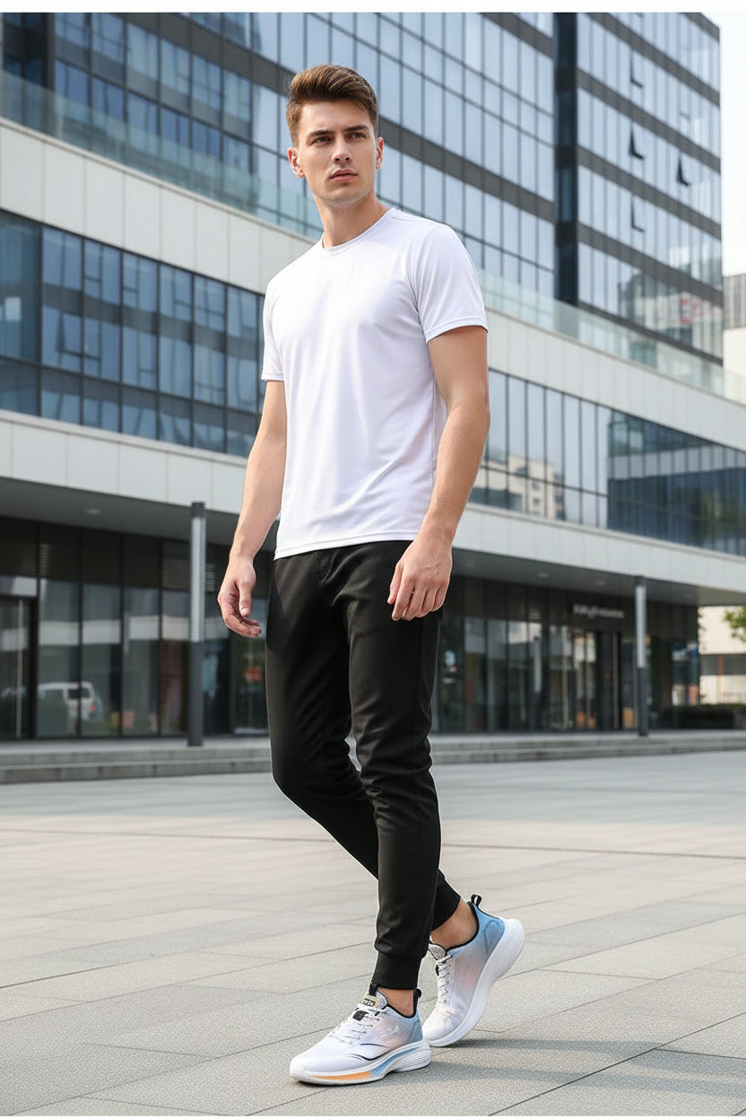 White and blue running shoes with orange accents worn by a person on a gray background.