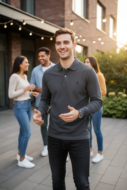 Gray polo shirt held by a hand with a blurred background of more shirts on hangers.