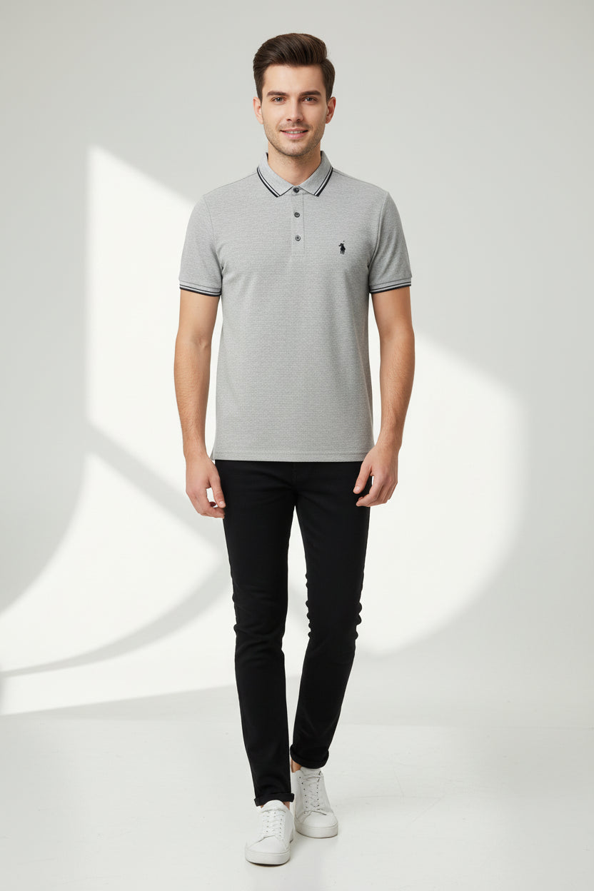 Gray polo shirt with a brand logo on a hanger in a clothing store.