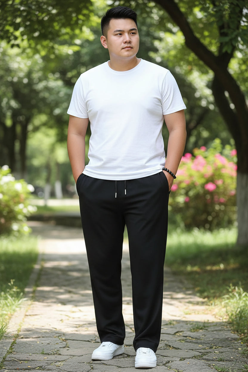 Person wearing black pants with a plain background