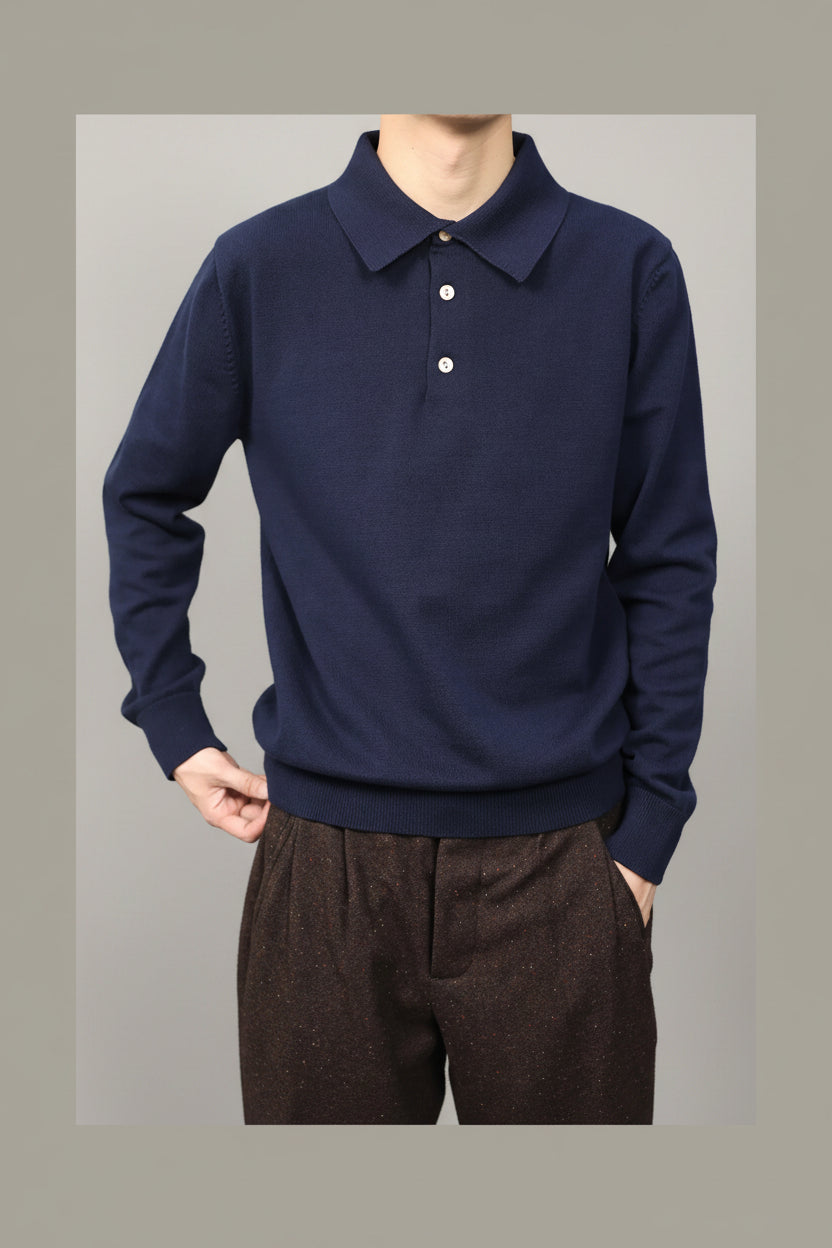 Person wearing a navy long-sleeve polo shirt against a green background