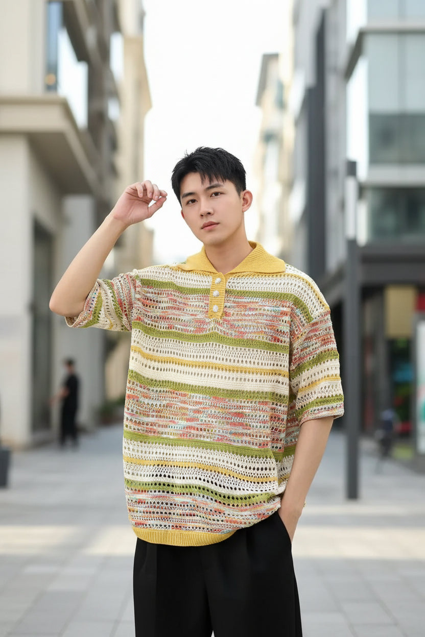 Person wearing a colorful patterned shirt and black cap against a gray background
