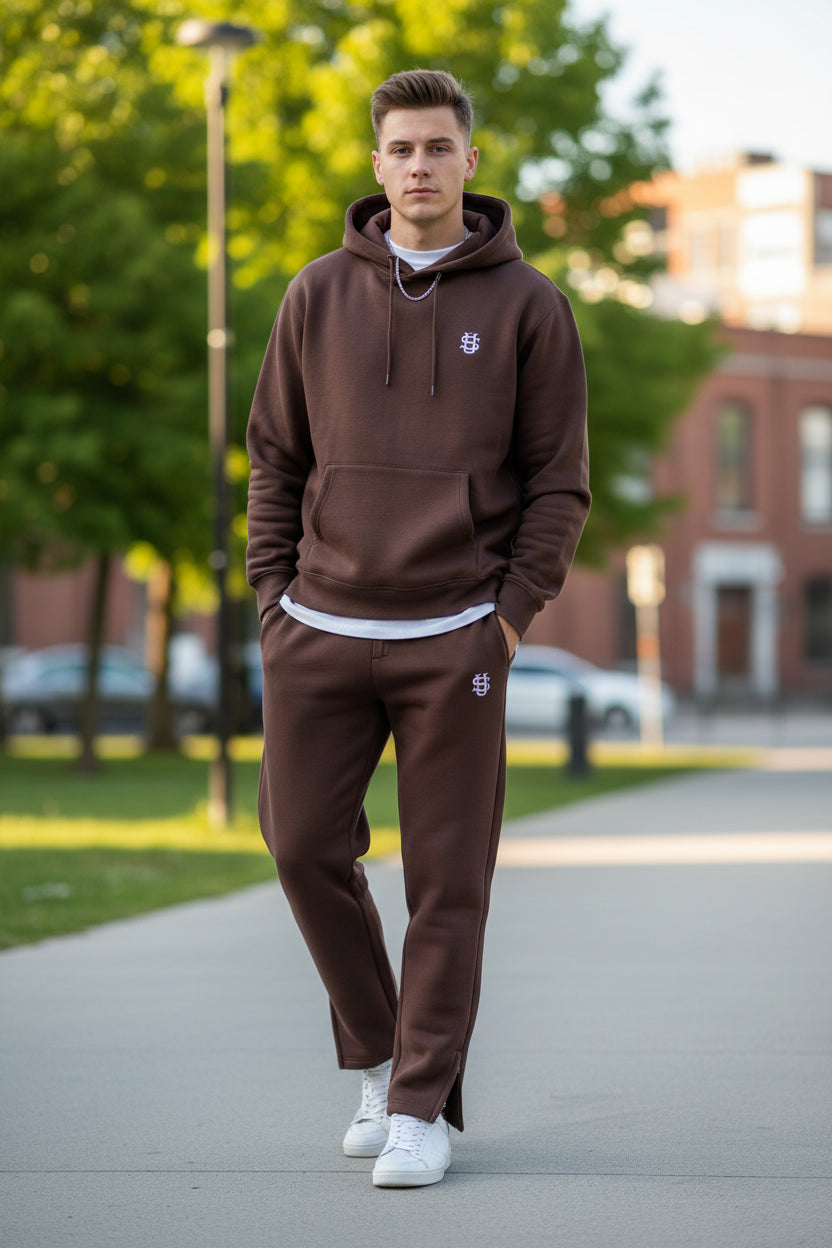 Brown sweatpants with a logo on a gray concrete surface