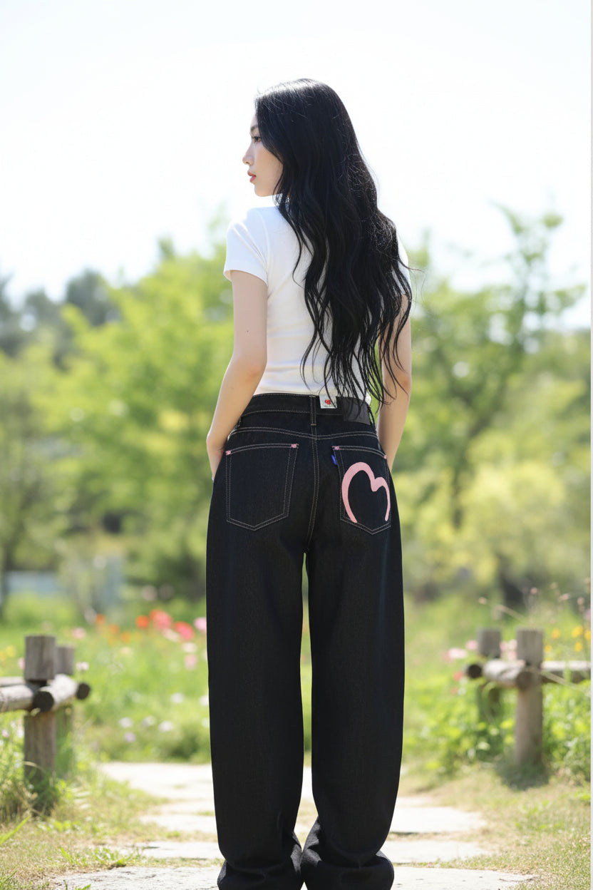 Person wearing black jeans with a heart design on a white background