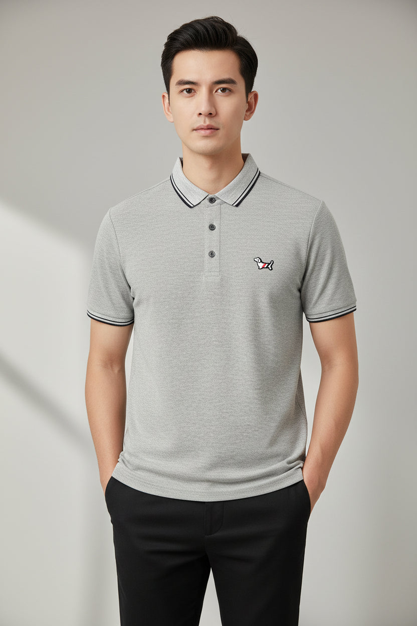 Gray polo shirt with a brand logo on a hanger in a clothing store.