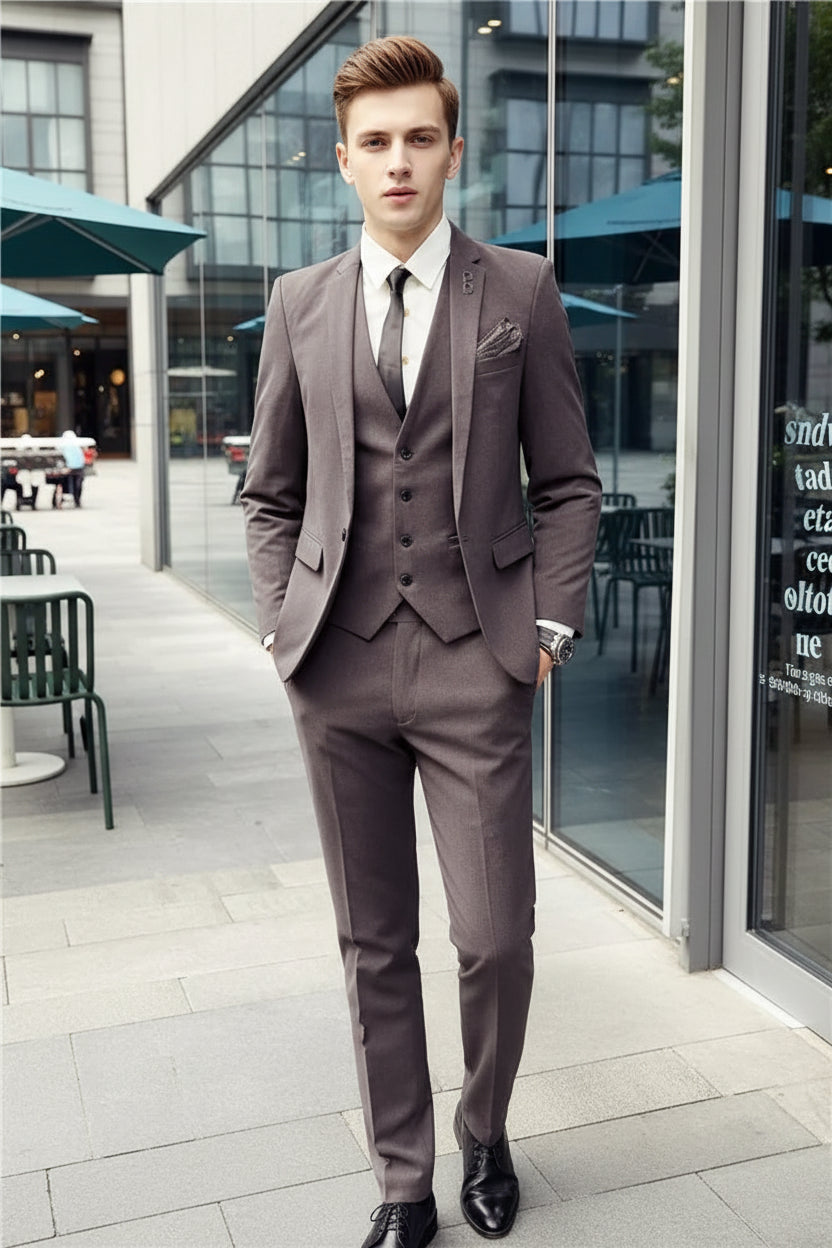 Man wearing a brown suit standing in front of a store with glass windows.