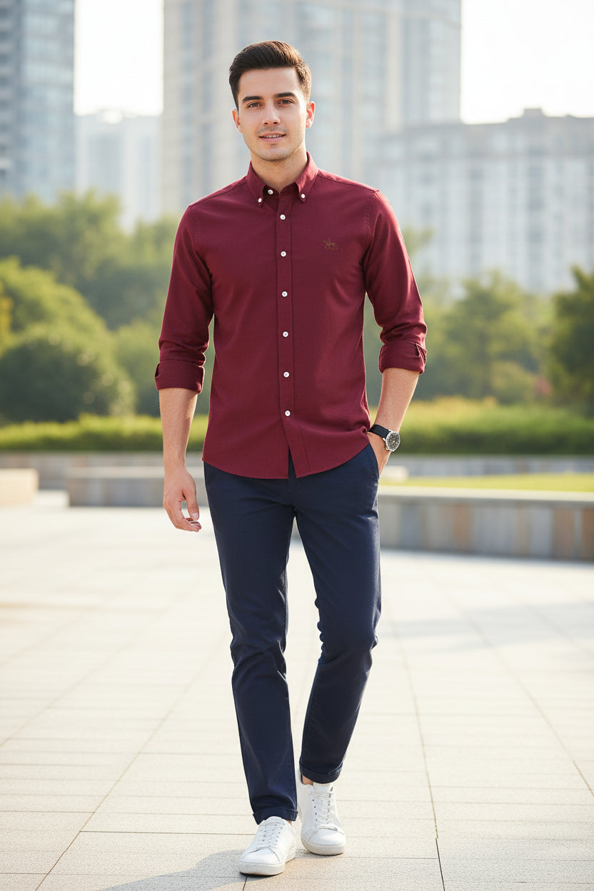 Folded maroon shirt with a logo on a white background