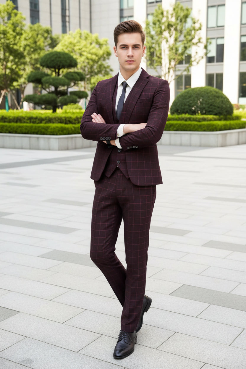 Man wearing a red plaid suit standing in front of a glass door.