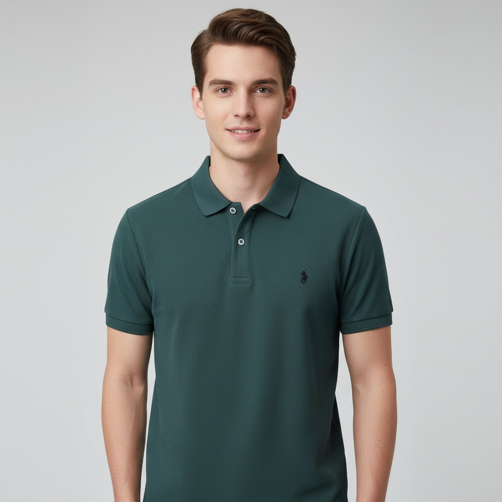 Green polo shirt with a brand logo held by a hand, with other shirts in the background.