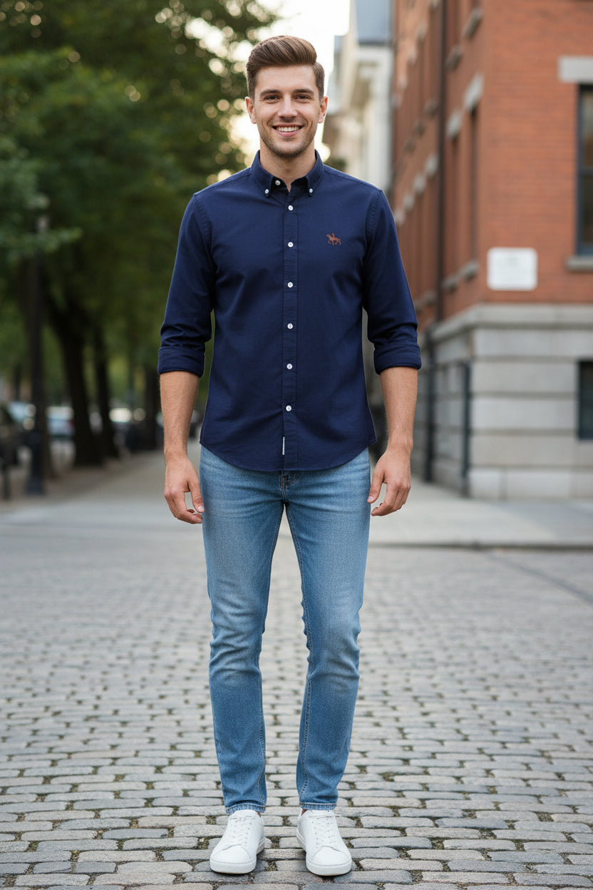 Navy blue shirt with white buttons and a logo on a light gray background