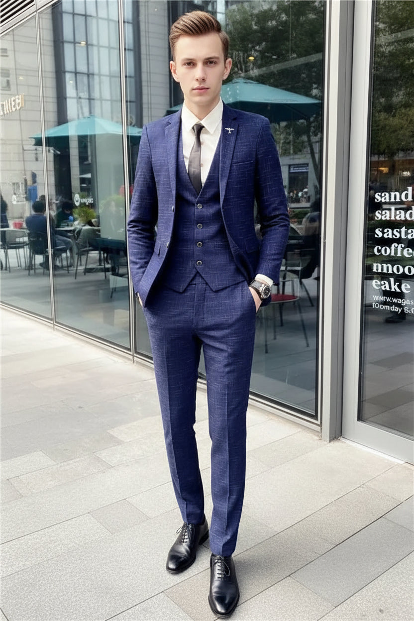 Man wearing a blue checkered suit standing in front of a store window.