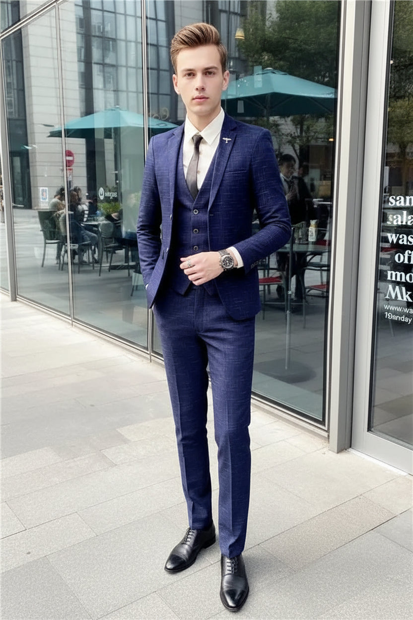 Man wearing a blue checkered suit standing in front of a store window.