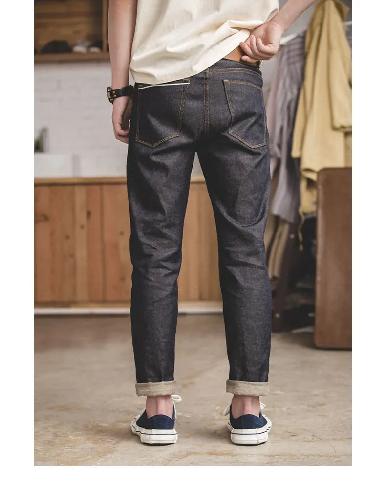 Person wearing dark jeans and white sneakers in a casual setting