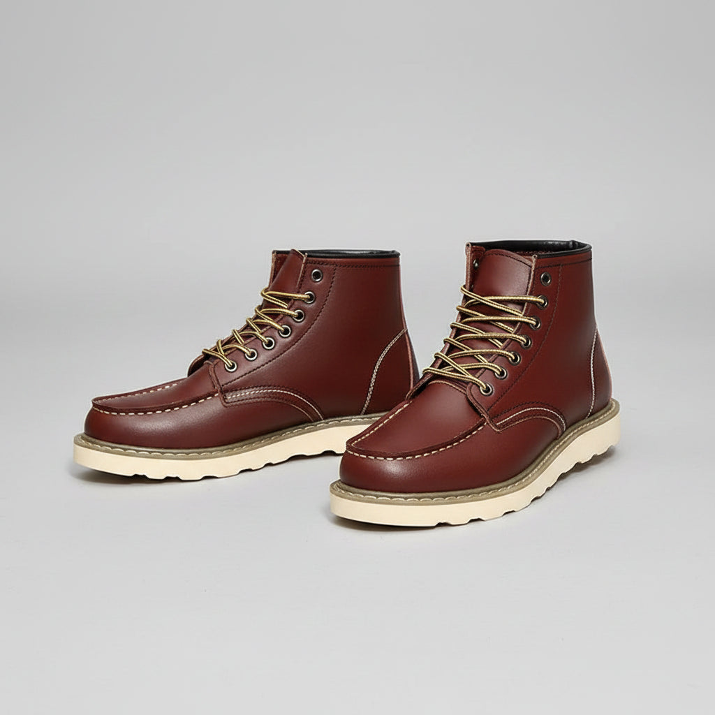 Brown leather boots with white soles worn by a person on a rustic background