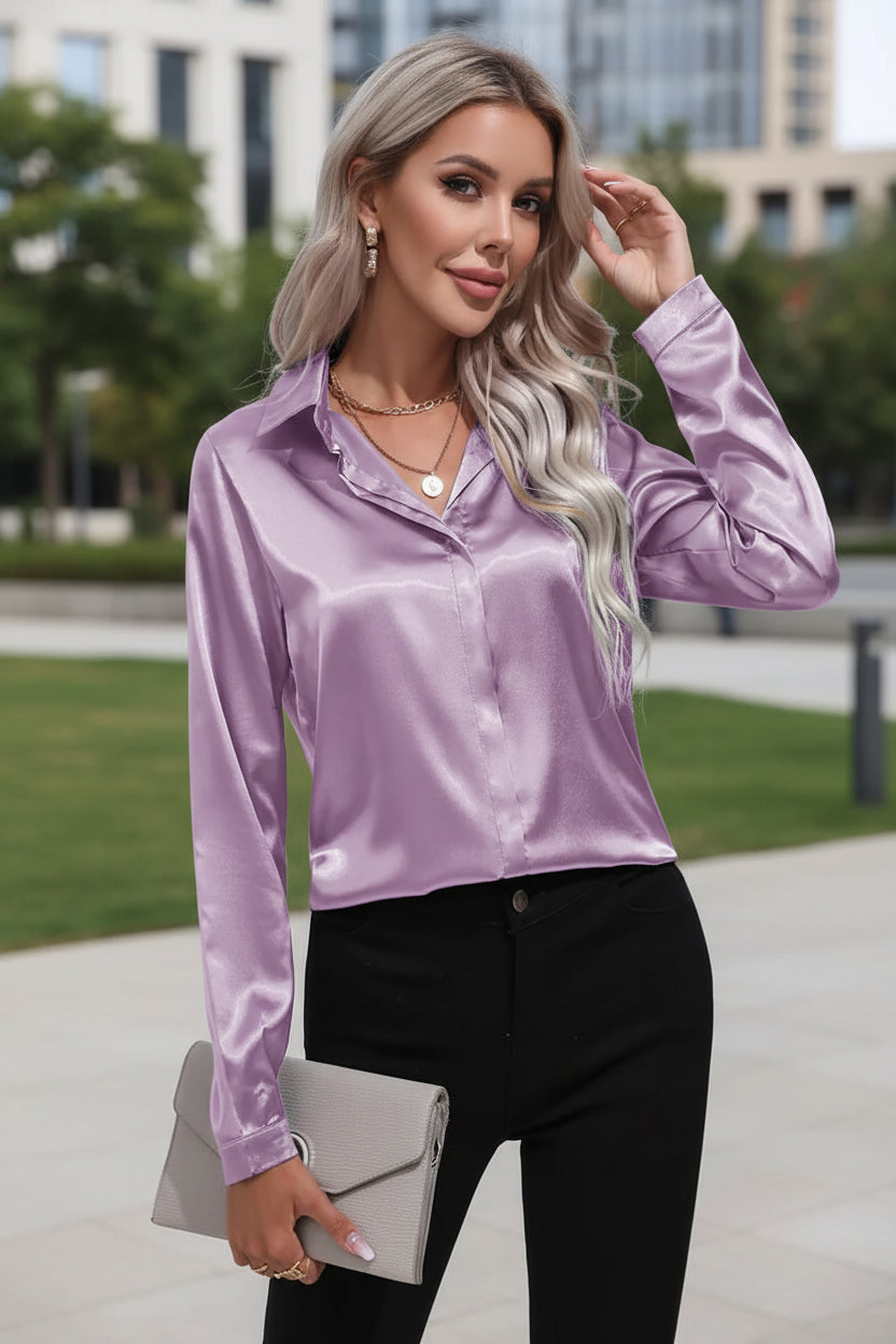 Woman wearing a purple satin blouse and black pants against a white background