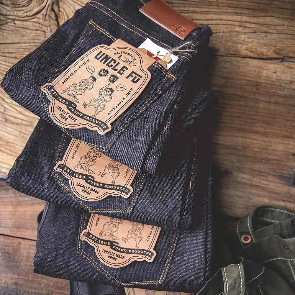 Folded dark blue jeans with 'Uncle Fred' label on a wooden surface